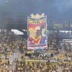 Pride Tifo dsiplaying three drag queens with their arms crossed. With Words "The Crew: Hardest Werking Team"